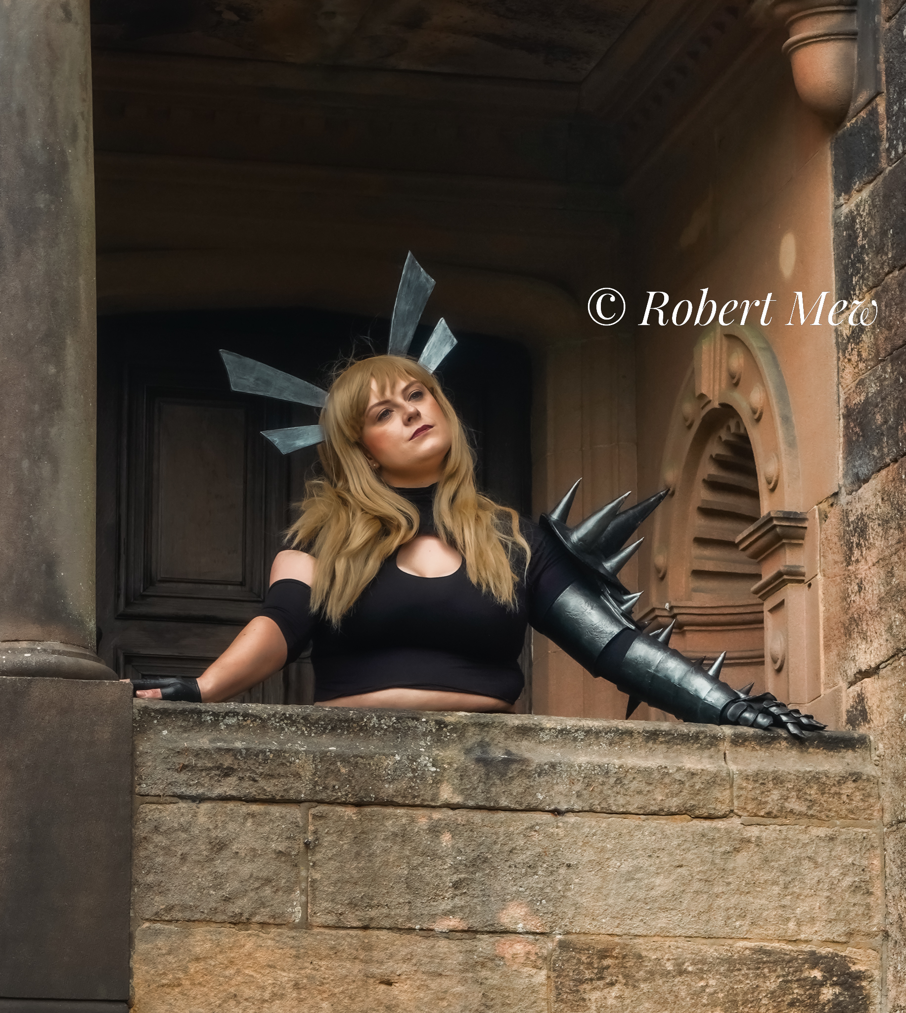 lady looks out from balcony with armour